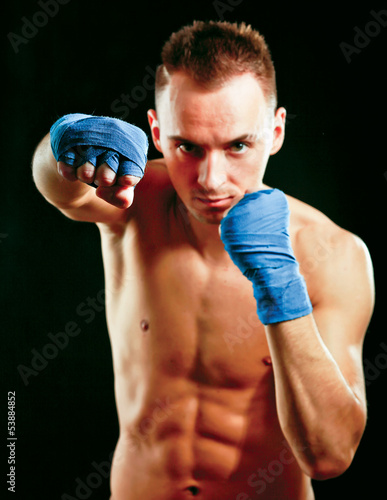 Photo: Young handsome boxer man isolated on black background Young handsome boxer man isolated on black background