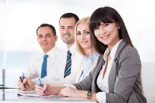 Photo: Business People Writing Meeting Notes Business People Writing Meeting Notes