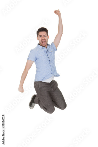 Photo: Young Man Jumping With Arms Raised Young Man Jumping With Arms Raised