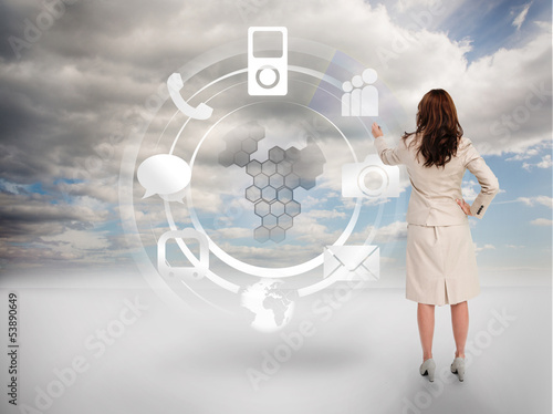 Photo: Businesswoman touching at a hologram with icons Businesswoman touching at a hologram with icons