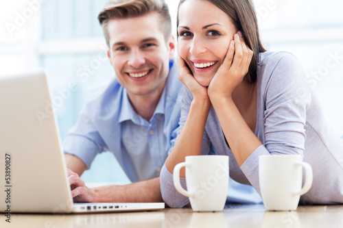 Photo: Couple on floor using laptop Couple on floor using laptop