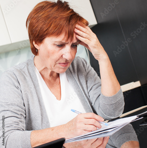 Photo: Elderly woman sorting through her old receipts Elderly woman sorting through her old receipts