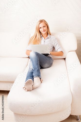 Photo: Woman on the sofa with laptop Woman on the sofa with laptop