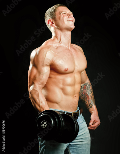 Photo: Handsome muscular man working out with dumbbells Handsome muscular man working out with dumbbells