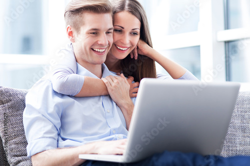 Photo: Couple on sofa with laptop Couple on sofa with laptop