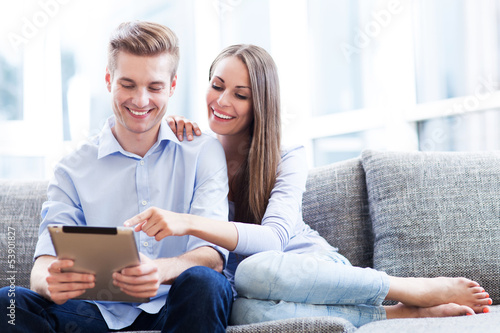 Photo: Couple on sofa with digital tablet Couple on sofa with digital tablet