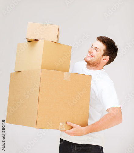 Photo: young man carrying carton boxes young man carrying carton boxes