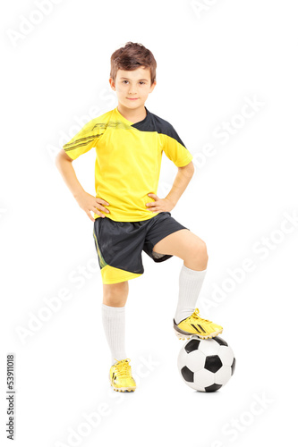 Photo: Full length portrait of a kid in sportswear posing with a soccer Full length portrait of a kid in sportswear posing with a soccer