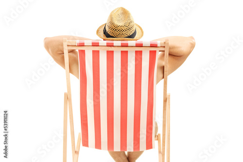 Photo: Man with hat sitting on a beach chair Man with hat sitting on a beach chair