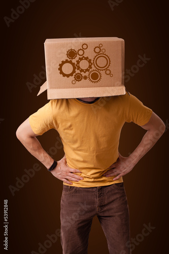 Photo: Young man gesturing with a cardboard box on his head with spur w Young man gesturing with a cardboard box on his head with spur w