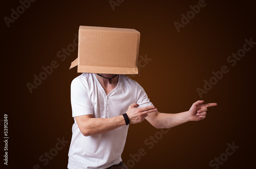 Photo: Young man gesturing with a cardboard box on his head Young man gesturing with a cardboard box on his head