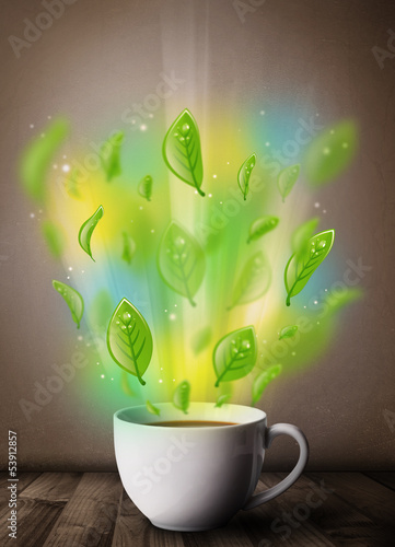 Photo: Tea cup with leaves and colorful abstract lights Tea cup with leaves and colorful abstract lights