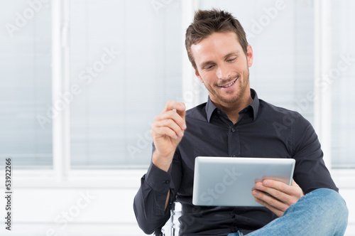 Photo: Young Man Using Digital Tablet Young Man Using Digital Tablet