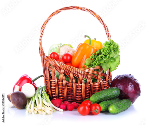 Photo: Fresh vegetables in wicker basket isolated on white Fresh vegetables in wicker basket isolated on white