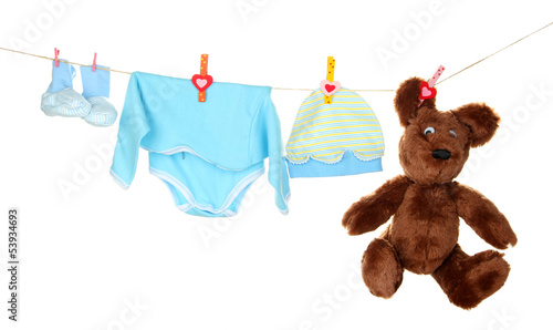 Photo: Baby clothes hanging on clothesline, isolated on white Baby clothes hanging on clothesline, isolated on white