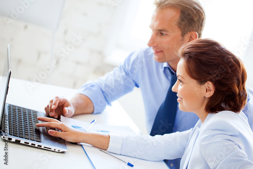 Photo: man and woman working with laptop in office man and woman working with laptop in office