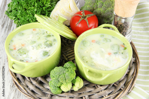 Photo: Cabbage soup in plates on braided tray on napkin on wooden Cabbage soup in plates on braided tray on napkin on wooden