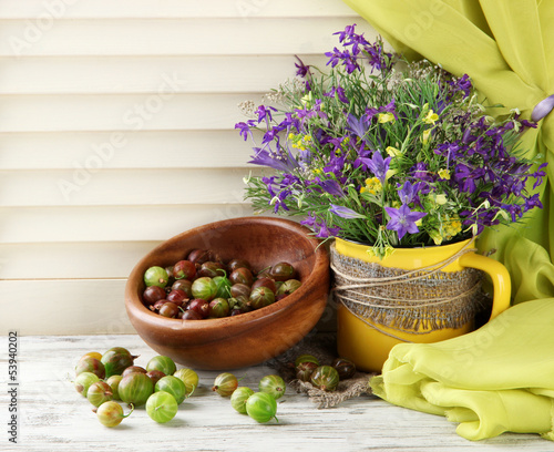 Photo: Beautiful bouquet of wildflowers in cup and berries Beautiful bouquet of wildflowers in cup and berries
