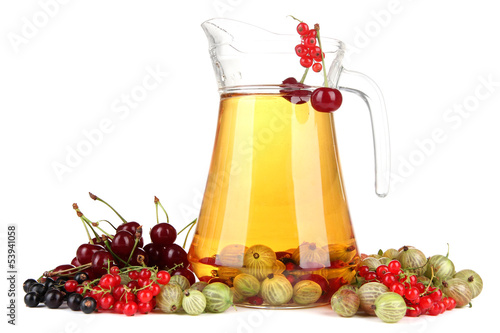 Photo: Glass pitcher of compote with different summer berries isolated Glass pitcher of compote with different summer berries isolated