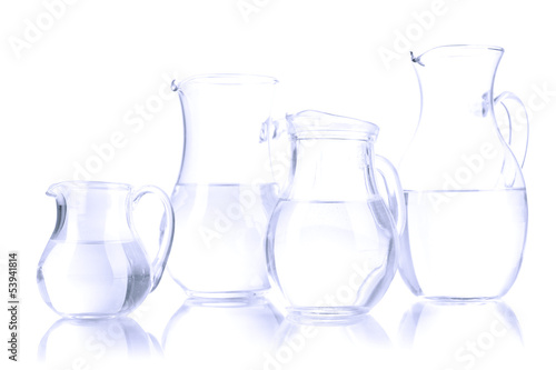 Photo: Glass pitchers of water isolated on white Glass pitchers of water isolated on white