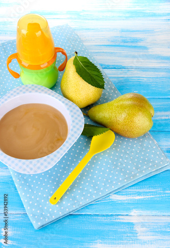 Photo: Tasty baby fruit puree and baby bottle on wooden table Tasty baby fruit puree and baby bottle on wooden table
