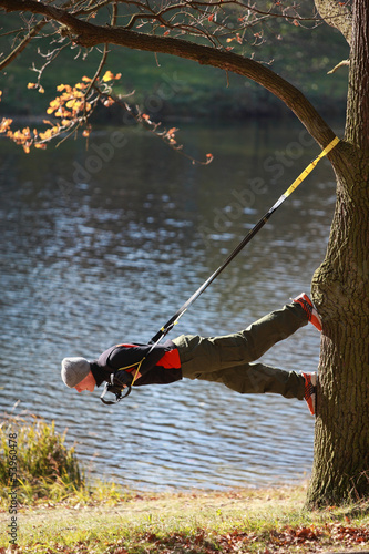 Photo: suspension training at the river - man on tree suspension training at the river - man on tree
