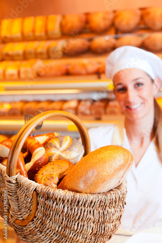 Photo: Bäckerin verkauft Brot im Korb in Bäckerei Bäckerin verkauft Brot im Korb in Bäckerei