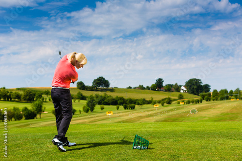 Photo: Young female golf player at Driving Range Young female golf player at Driving Range