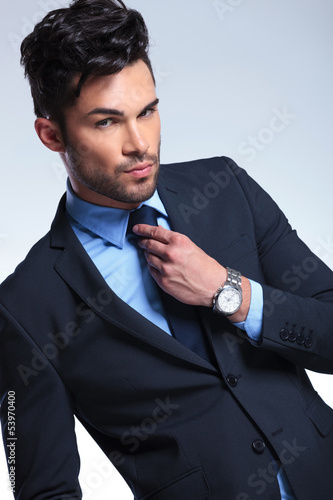 Photo: business man fixes his tie business man fixes his tie