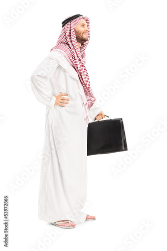 Photo: Full length portrait of a male arab person with suitcase posing Full length portrait of a male arab person with suitcase posing