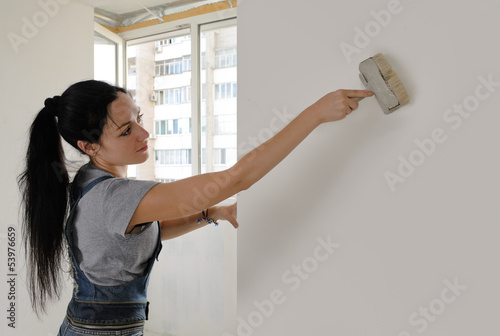 Photo: Attractive woman painting a house wall Attractive woman painting a house wall