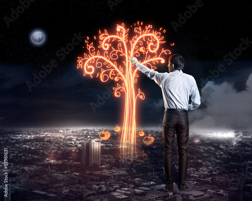 Photo: Businessman draws a glowing signs Businessman draws a glowing signs