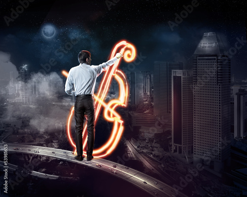 Photo: Businessman draws a glowing signs Businessman draws a glowing signs