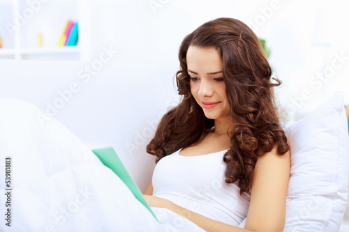 Photo: Young woman at home with a book Young woman at home with a book