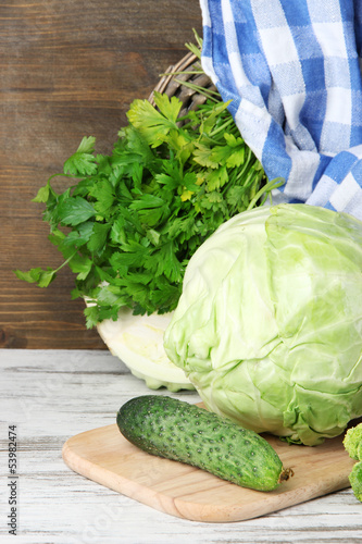 Photo: Composition of vegetables on table on wooden background Composition of vegetables on table on wooden background