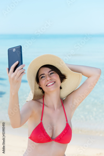 Photo: lachende frau fotografiert sich selbst am strand lachende frau fotografiert sich selbst am strand