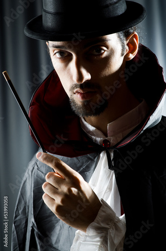 Photo: Magician in the dark room with wand Magician in the dark room with wand