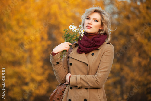 Photo: Young woman with a flowers in autumn forest Young woman with a flowers in autumn forest
