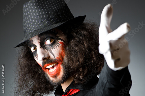 Photo: Joker personification with man in dark room Joker personification with man in dark room