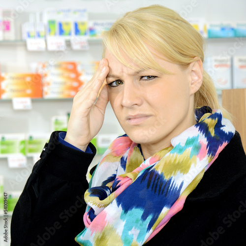 Photo: Frau mit Migräne in Apotheke Frau mit Migräne in Apotheke