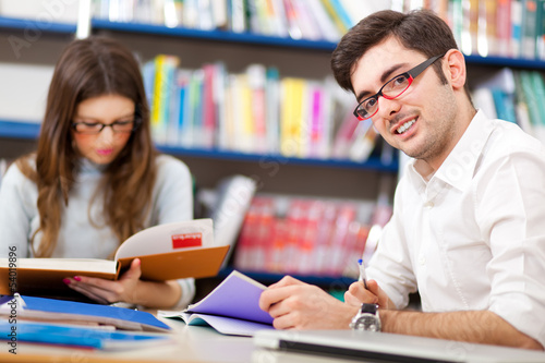 Photo: Couple of students in a library Couple of students in a library