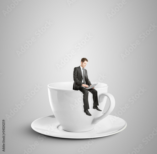 Photo: man sitting on cup man sitting on cup
