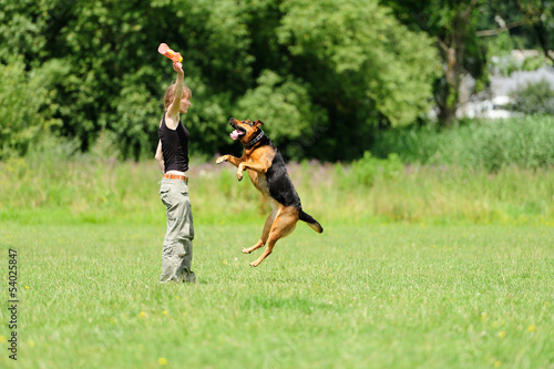 Photo: Girl playing with dog on green grass Girl playing with dog on green grass