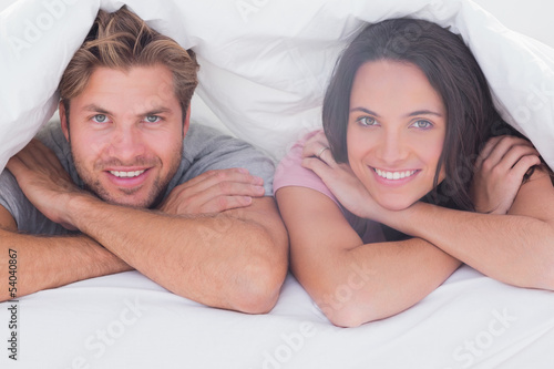 Photo: Couple smiling under the duvet Couple smiling under the duvet