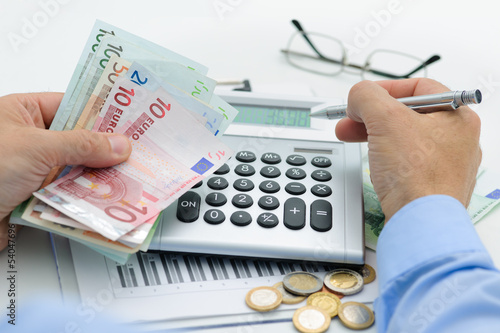 Photo: Hände mit Taschenrechner und Geld Hände mit Taschenrechner und Geld