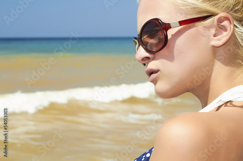 Photo: Beautiful blond woman on the beach in sunglasses Beautiful blond woman on the beach in sunglasses