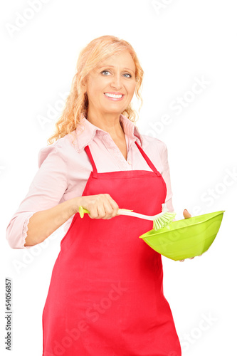 Photo: Blond woman wearing red apron and holding kitchen utensil Blond woman wearing red apron and holding kitchen utensil