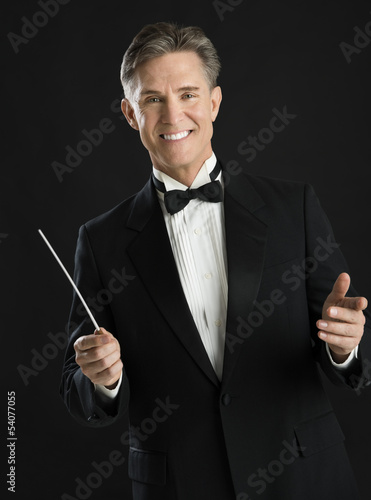 Photo: Portrait Of Confident Male Music Conductor Holding His Baton Portrait Of Confident Male Music Conductor Holding His Baton