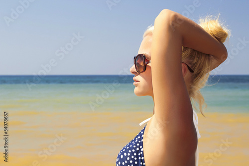 Photo: Beautiful blond woman on the beach in sunglasses Beautiful blond woman on the beach in sunglasses