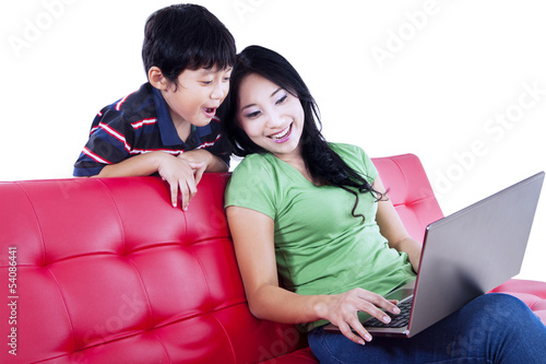 Photo: Mother and son quality time on red sofa - isolated Mother and son quality time on red sofa - isolated